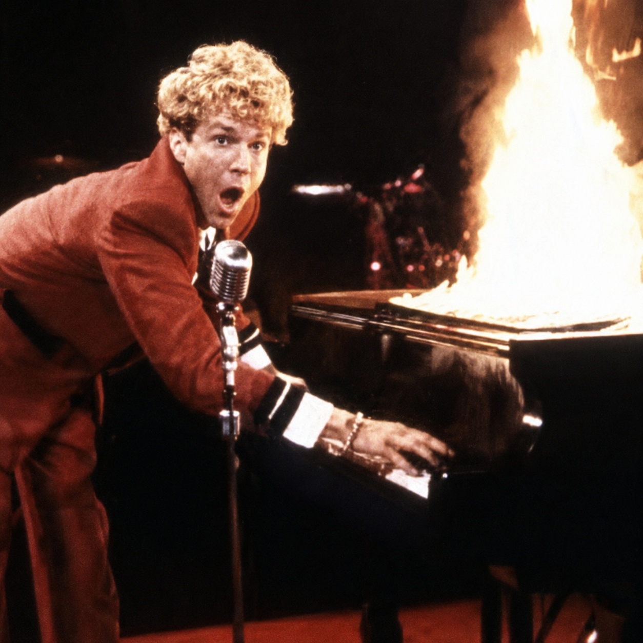 Jerry Lee Lewis diante de um piano em chamas
